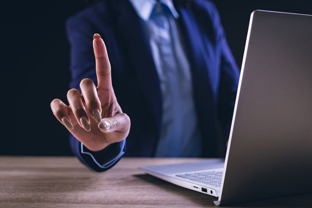 Businesswoman interacting with holographic interface on a laptop, symbolizing ethical digital marketing practices.